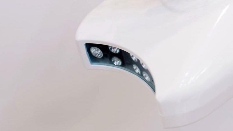 The curved head of a dental whitening lamp, its array of blue LEDs visible against a white background.