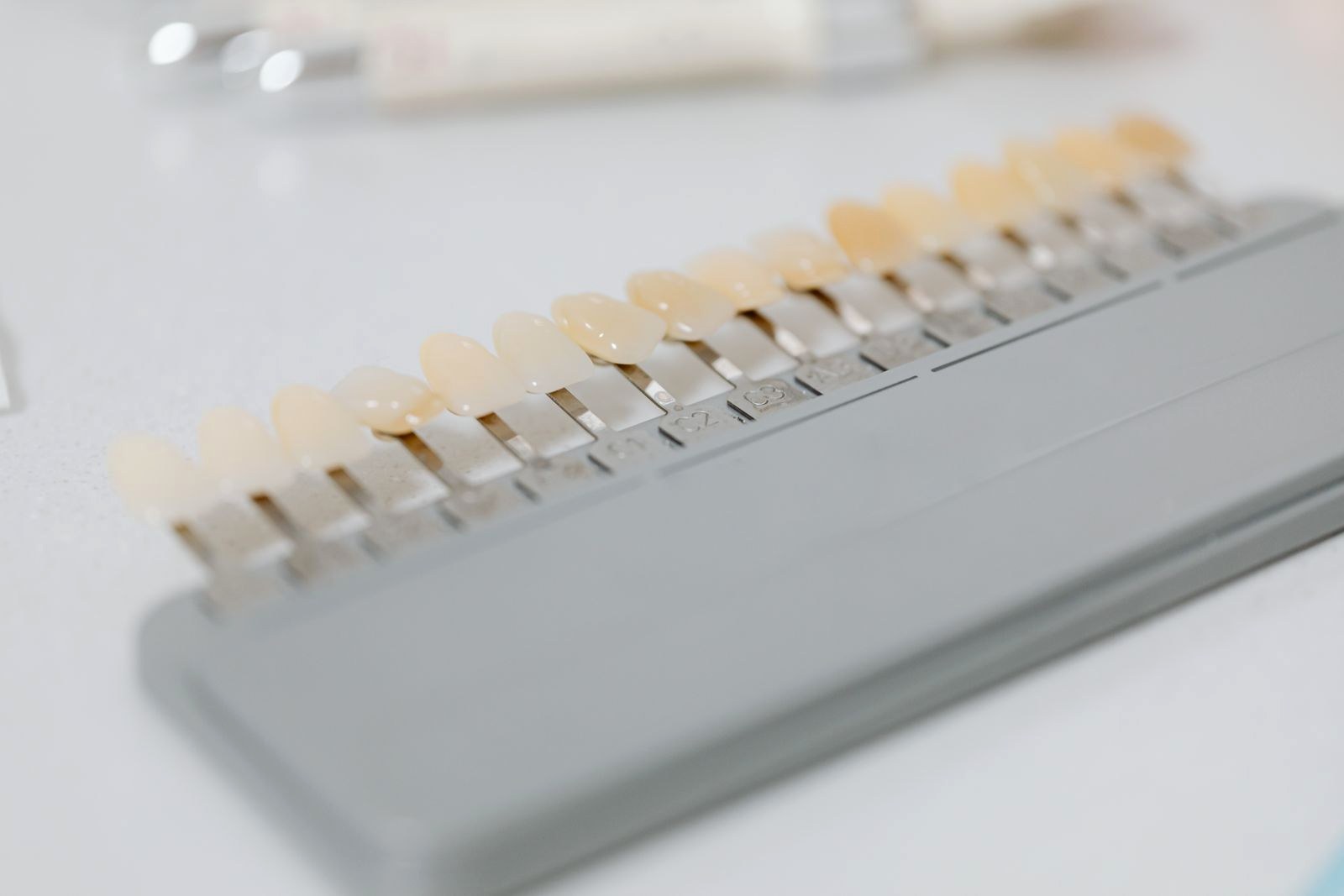 A row of tooth shade tabs running from bright to dark on a white tray.